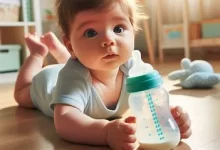 نوزاد در حال بازی با شیشه شیر، تغذیه ترکیبی نوزاد