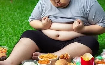 مرد چاقی با چربی اضافی شکم در حال خوردن فست فود