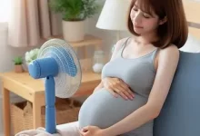 زن بارداری به خاطر گرگرفتگی بارداری روبروی پنکه نشسته است