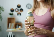 آیا کراتین باعث یبوست می شود؟ تصیور زنی با لباس ورزشی و بطری حاوی محلول کراتین