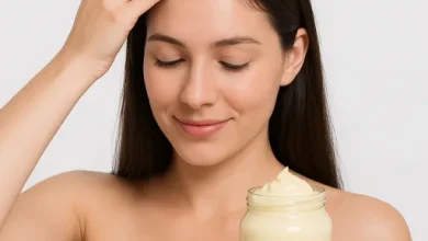 تصویر یک زن جوان در حال مالیدن ماسک سس مایونز بر روی موهایش