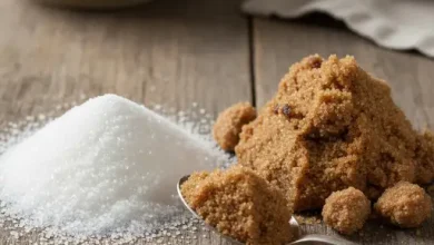 تصویر مقداری شکر سفید و شکر قهوه ای رو میز چوبی