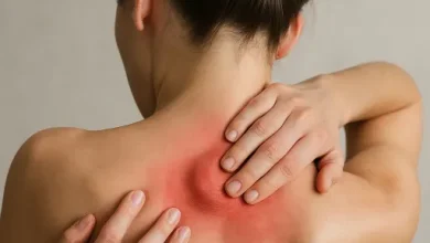 زن جوانی که دچار گره عضلانی در عضله ذوزنقه ای پشت شده است